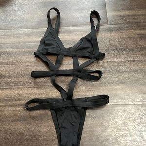 Really sexy black strappy clasp swimsuit. Clasps in back. Looks amazing on. Sz S